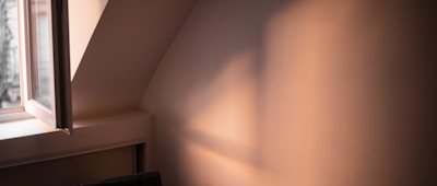 Soft natural light casting gentle shadows on neutral-toned walls in the hypnotherapy space.