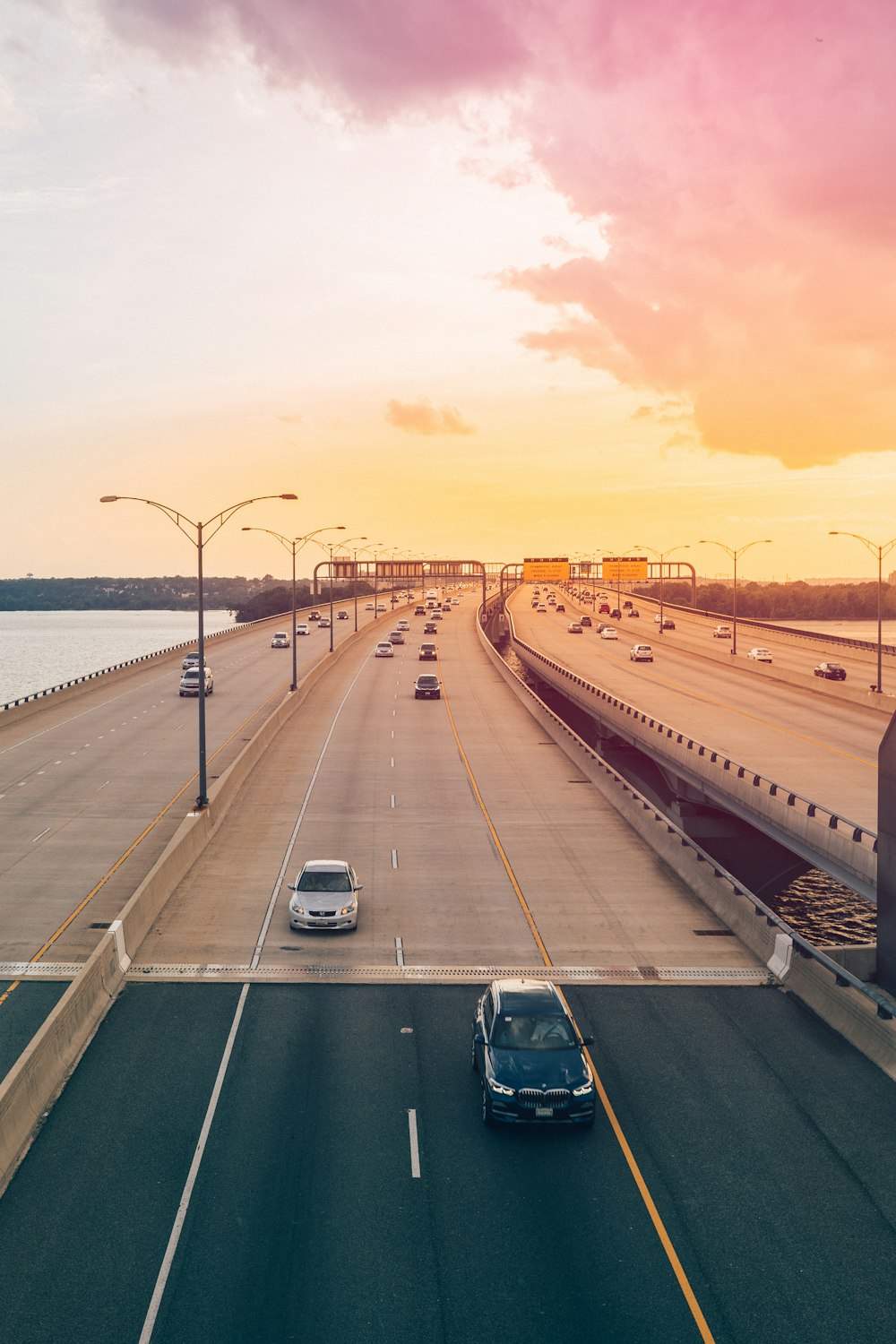 cars traveling on bridge expressway during sunset