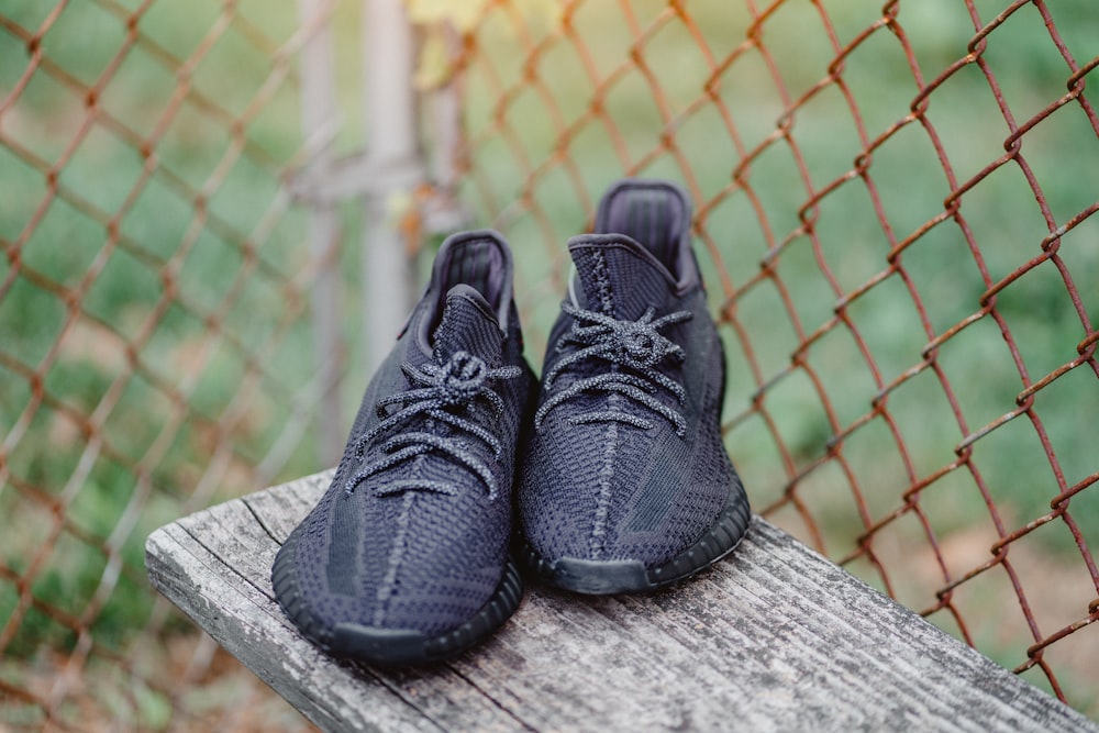 Foto un par de zapatos negros en un panel de madera marrón cerca de la  cerca de eslabones de cadena – Imagen Gris gratis en Unsplash