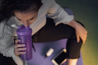 woman sipping on purple tumbler