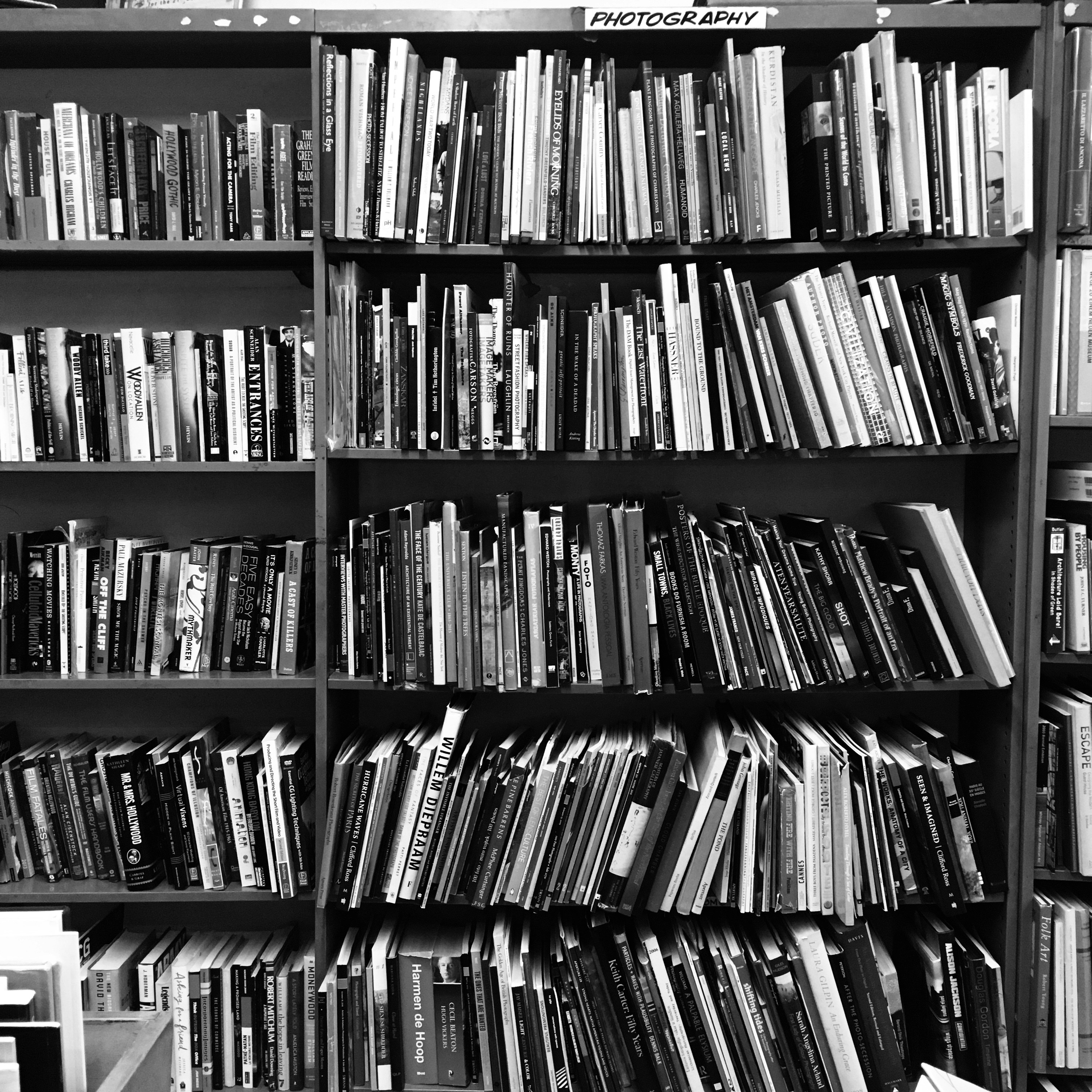 grayscale photo of books on a shelf