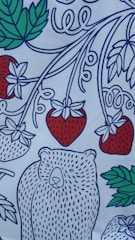 A stylized illustration featuring a white bear with dotted blue patterns on its body, surrounded by large strawberries with red and green colors, and green leaves. The design has swirling blue lines interconnecting the elements, creating a playful and decorative appearance.