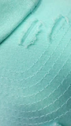 Close-up of a finely finished green shirt with detailed stitching and modern design.