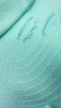 Close-up of a finely finished green shirt with detailed stitching and modern design.