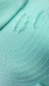 Close-up of gentle stitching on a mint green dog bed, highlighting craftsmanship.