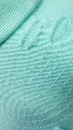 Close-up of a green blouse with delicate stitching and flowing fabric.