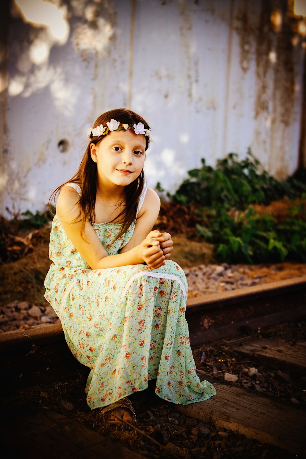 woman in floral maxi dress sitting on wood platform