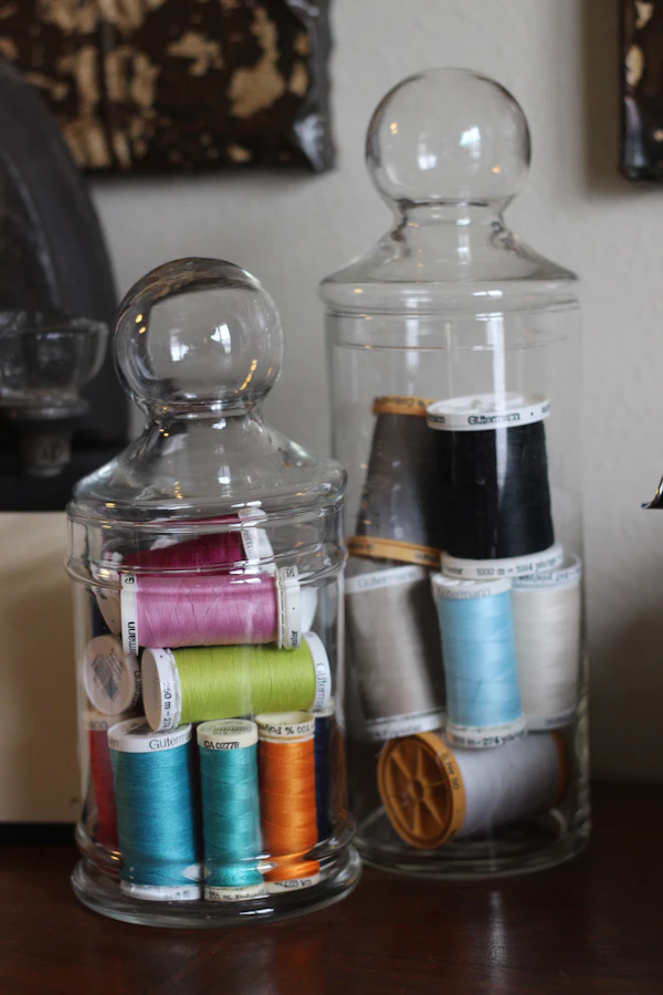 Glass jars filled with embroidery threads in many colours
