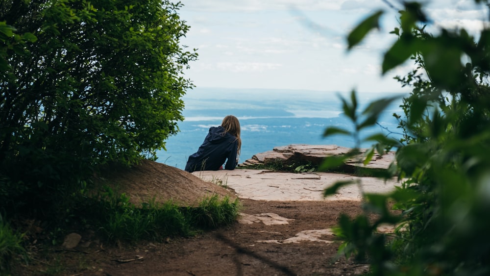 woman sitting on facing ocean