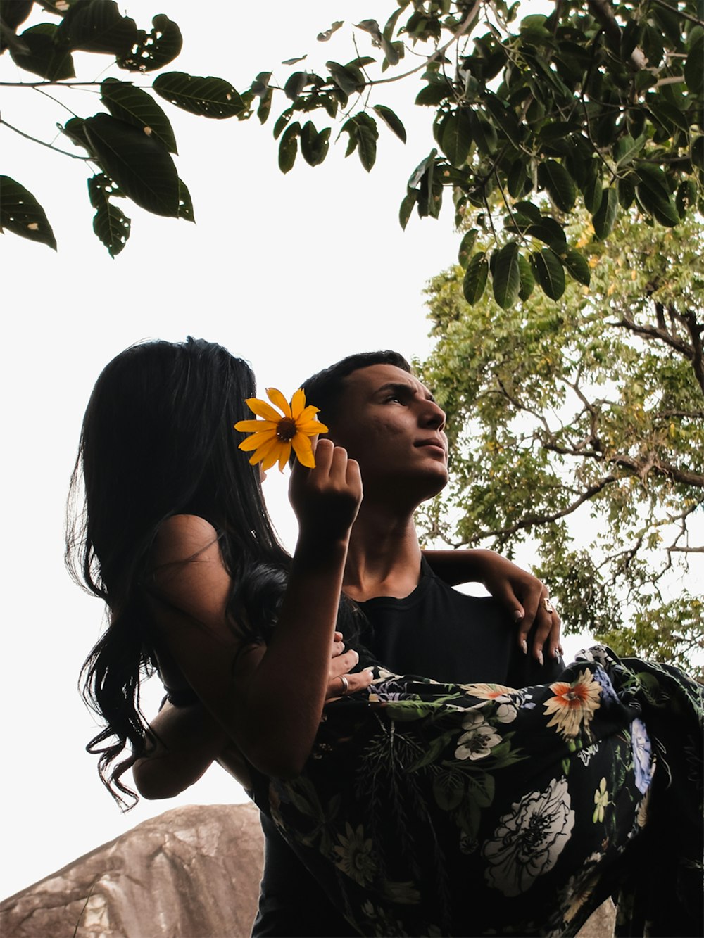 man caryying woman holdeing yellow flower