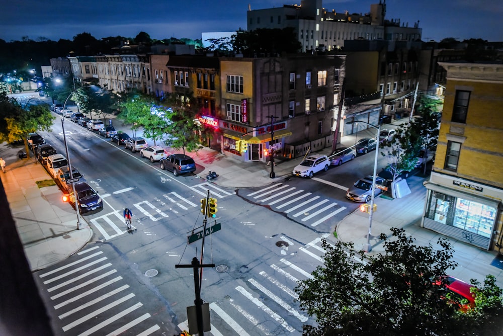 road crossing with cars near buildings during daytime with lights