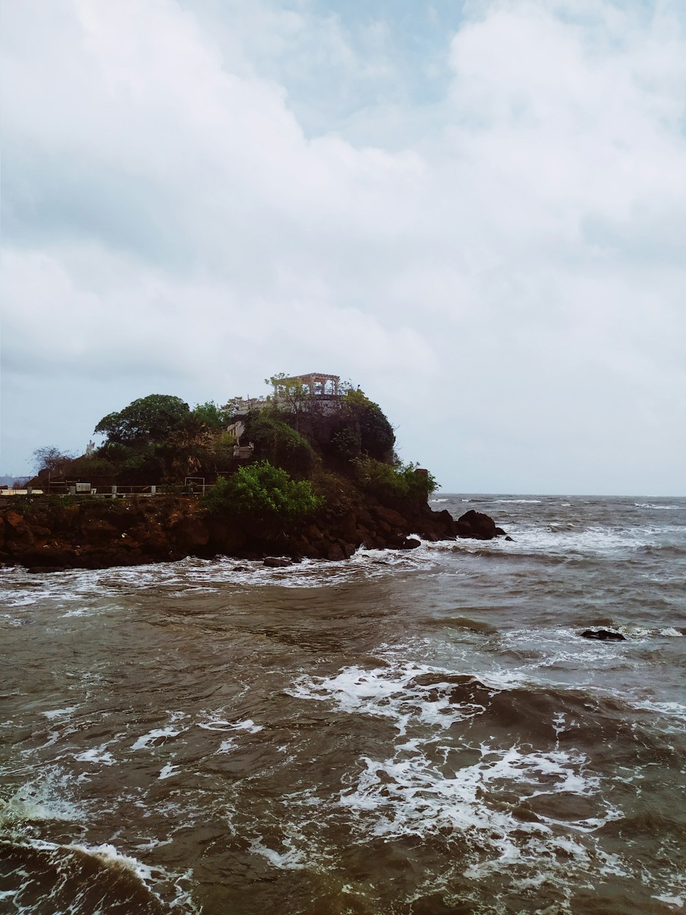 photography of ocean waves crashing on island during daytime