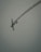 An aircraft is captured mid-flight, performing an acrobatic maneuver with a trail of smoke following behind against a muted sky. The vehicle is angled as if turning sharply, suggesting dynamic movement.