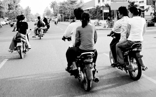grayscale photography unknown persons riding on motorcycle in Phnom Penh Cambodia