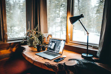 Cozy workspace with editing notes and a laptop displaying a manuscript.