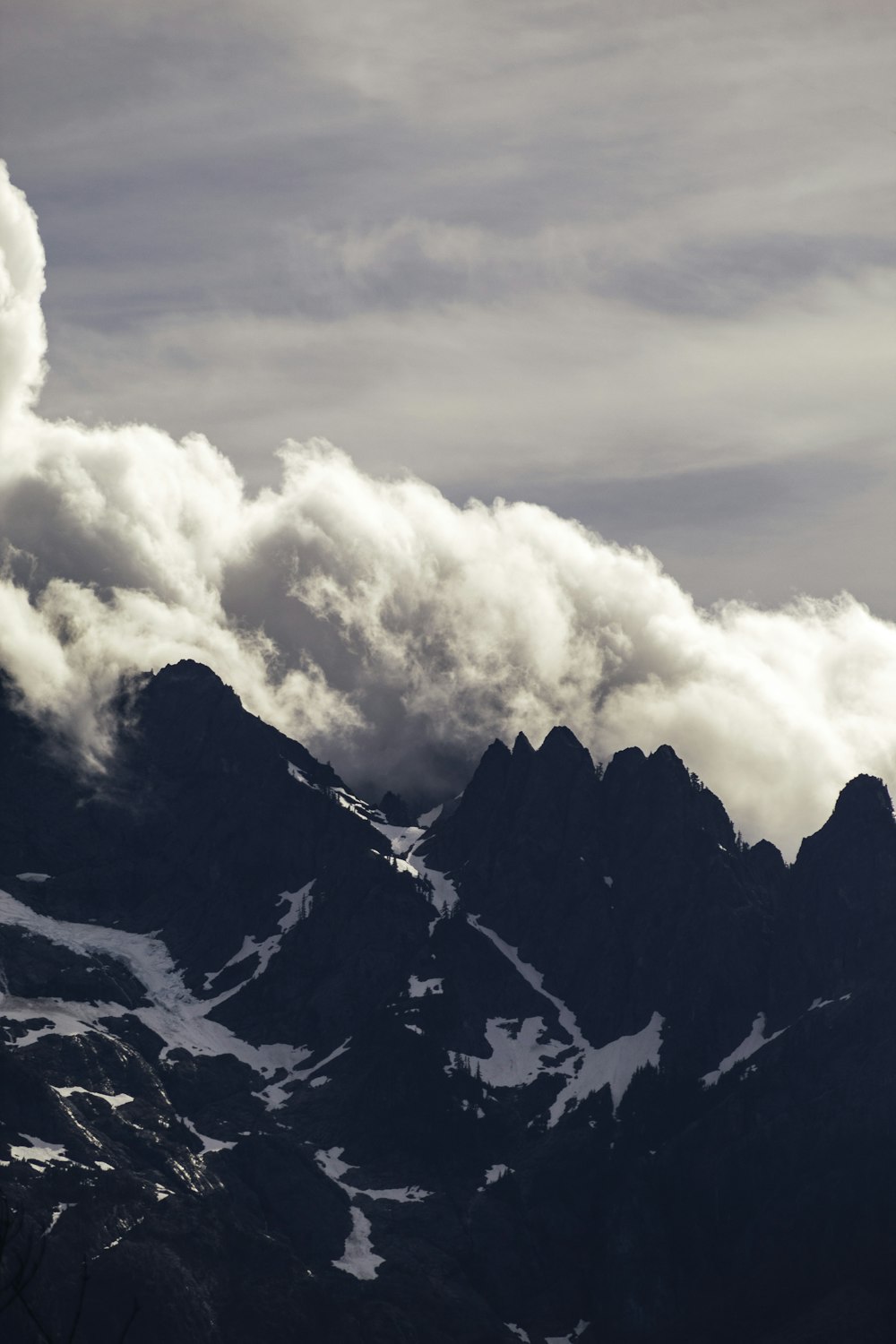 white clouds over black mountain peaks