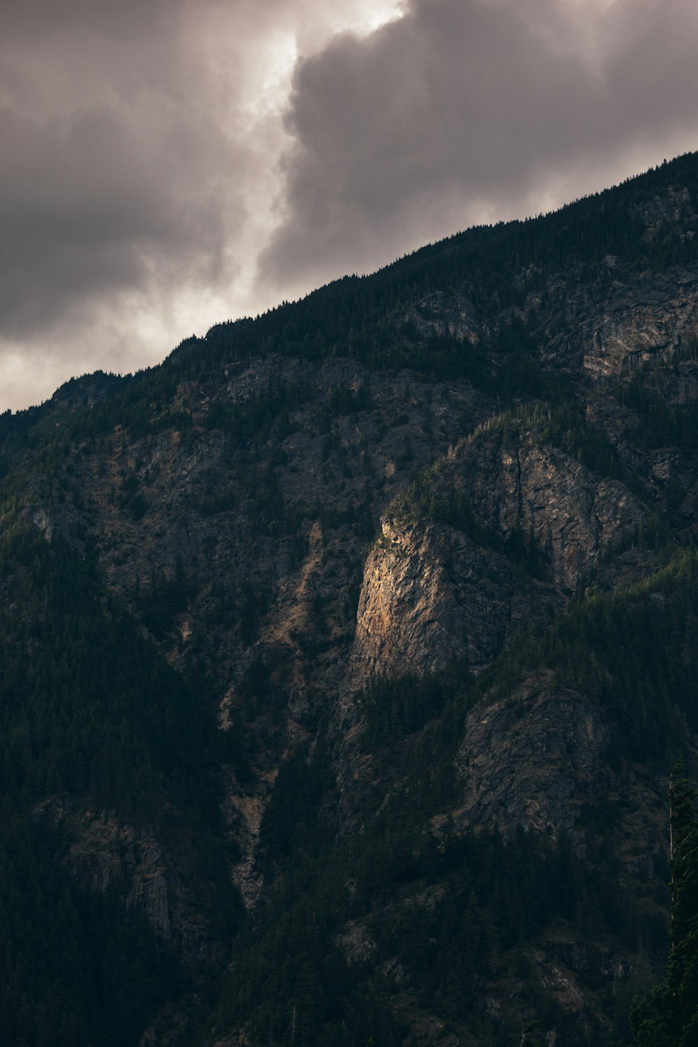 brown rock hill under grey sky