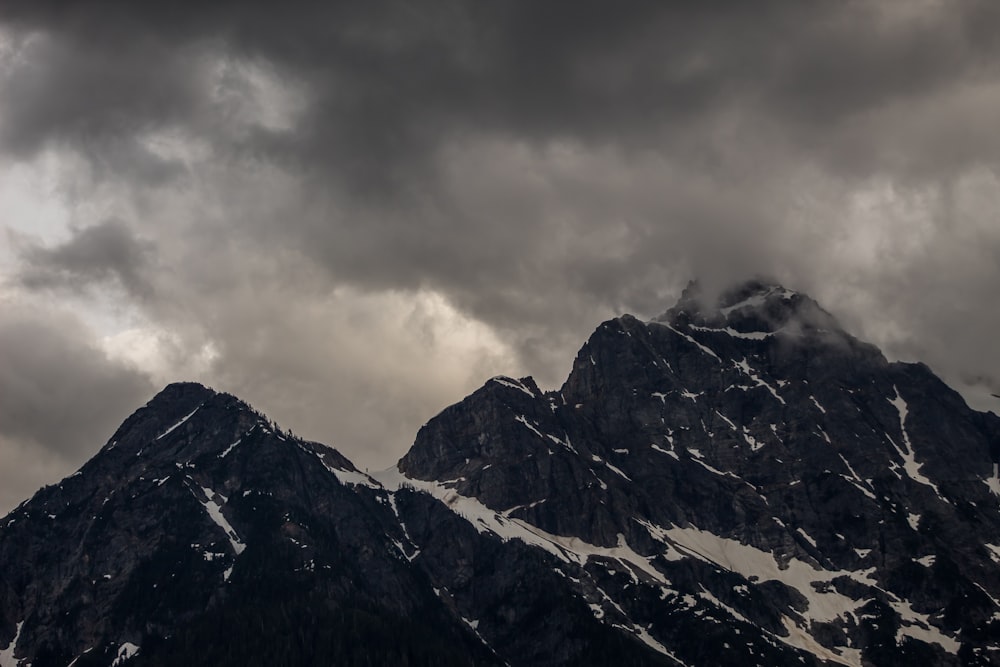 Blick auf den verschneiten Berg unter dunklen Wolken