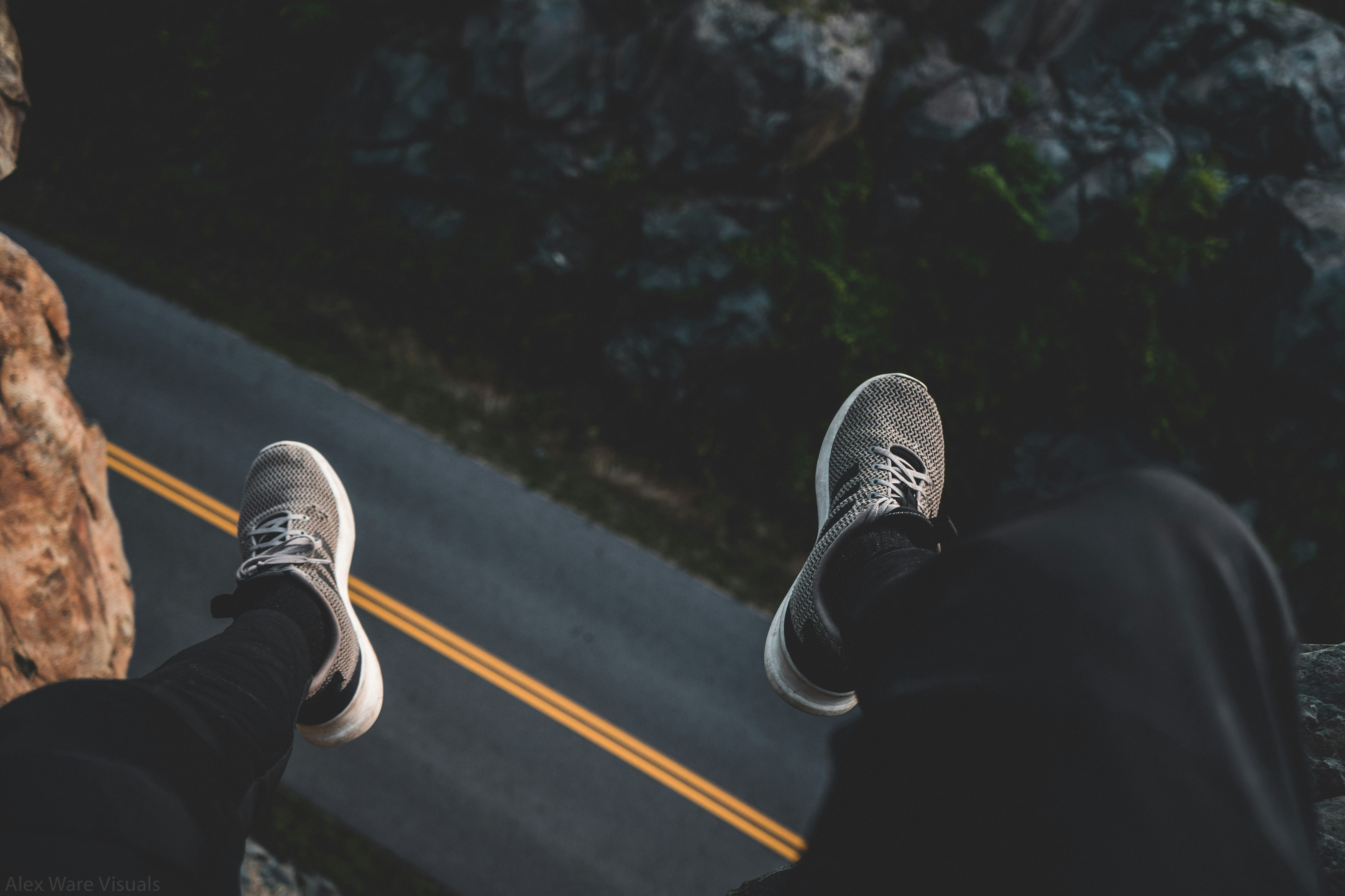 person sits at the edge of the cliff