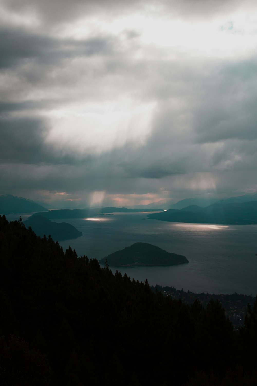 mountain near body of water under white clouds