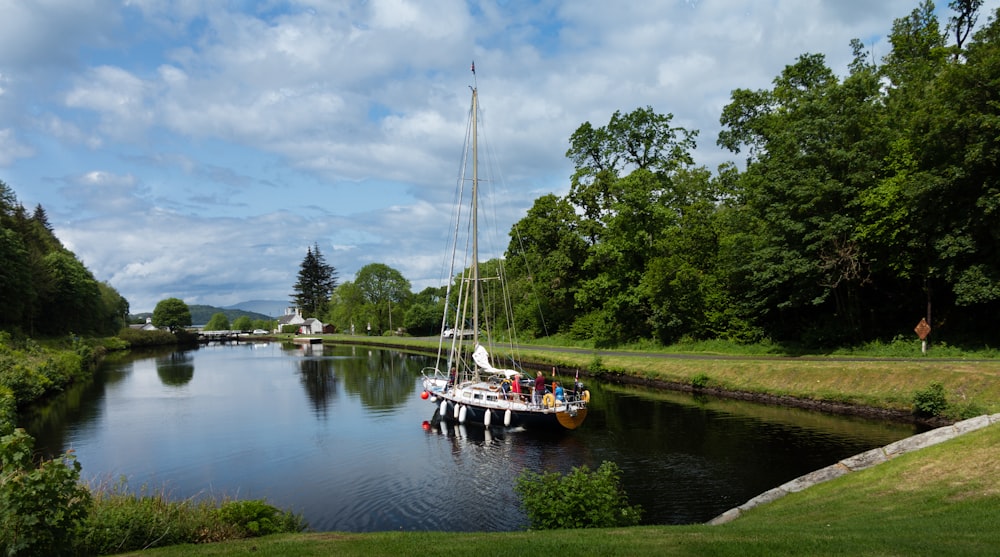 white boat on body of water under white clouds