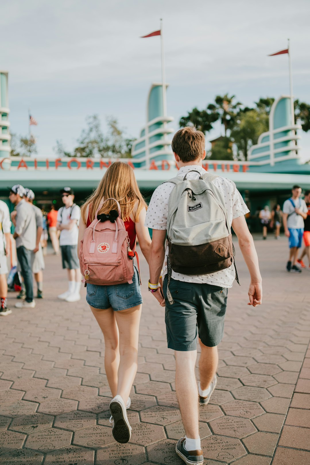 man and woman holding hands while walking towards building during daytime