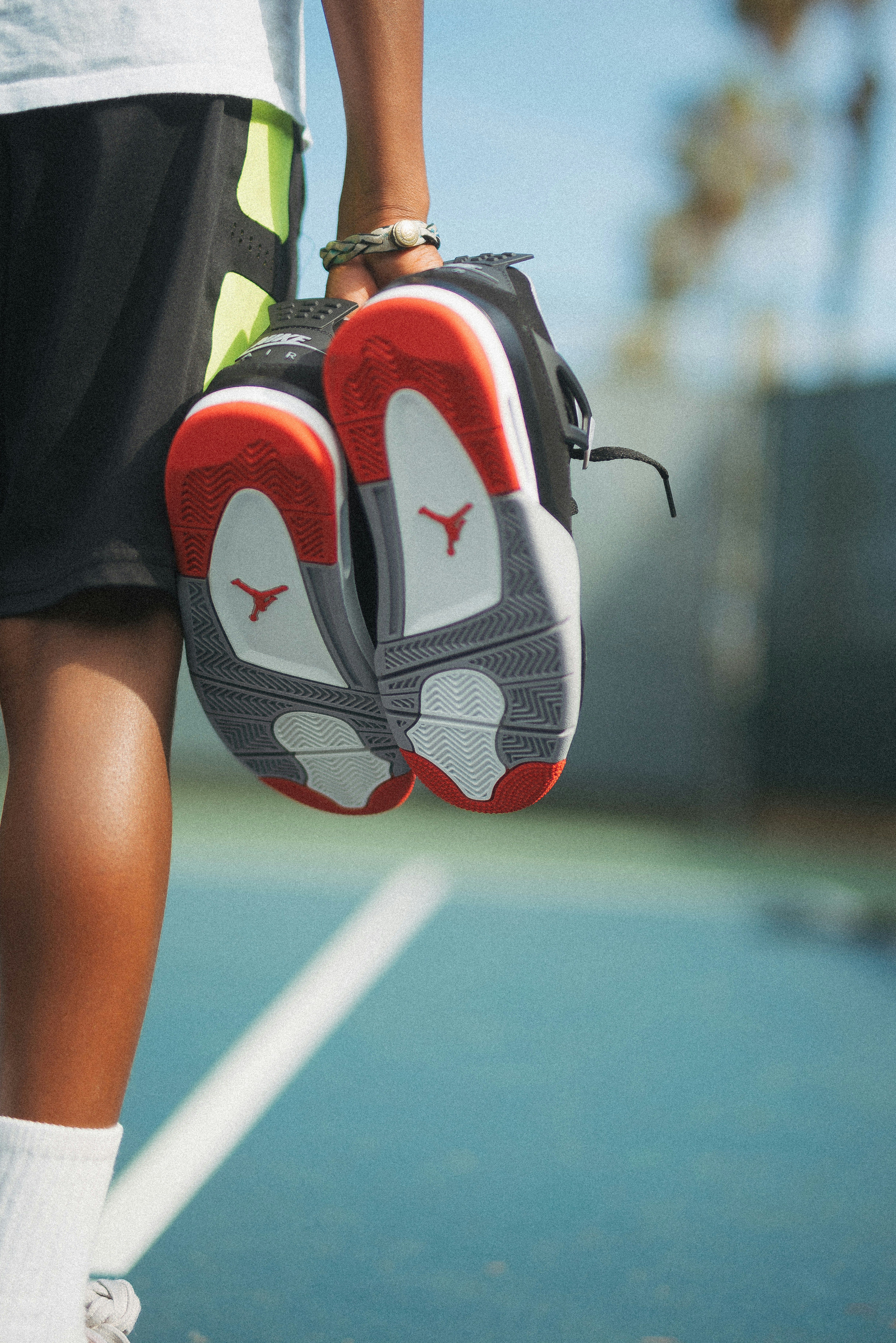 person holding orange,grey,white and black Air Jordan basketball during daytime close-up photography