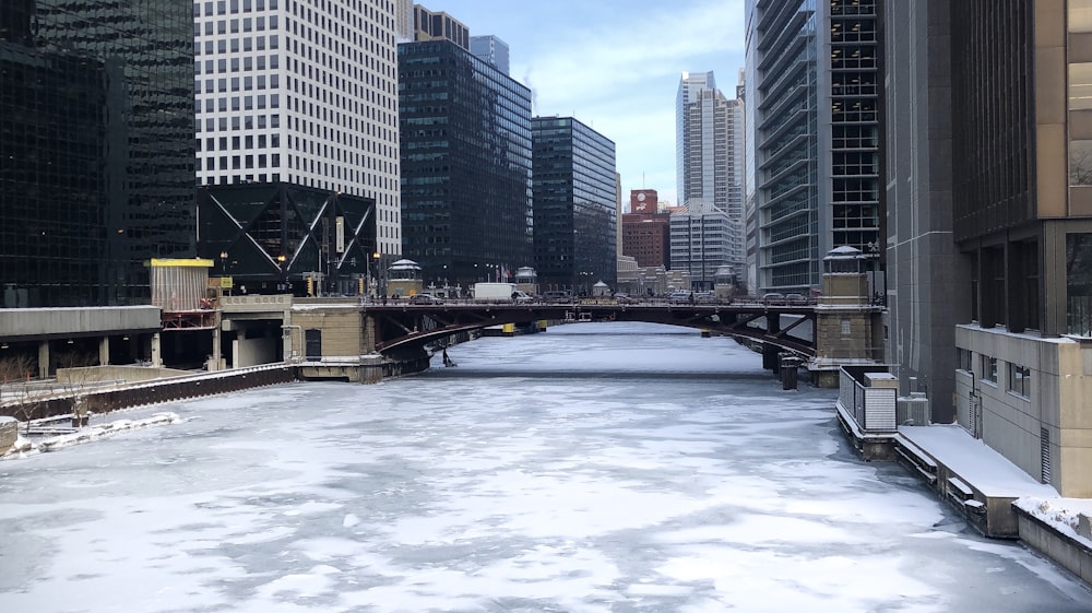 photography of frozen river and high-rise building during daytime