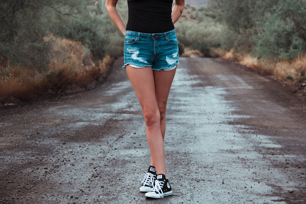 woman standing in the middle of road during daytime