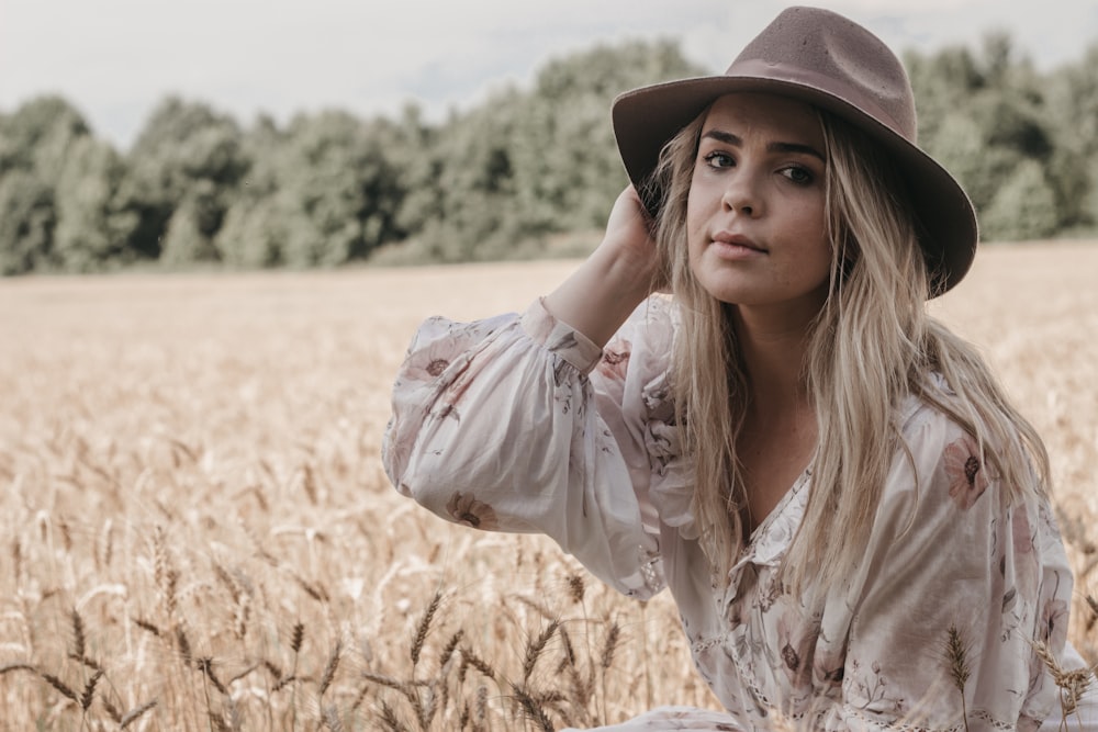 woman wearing brown hat an white floral top