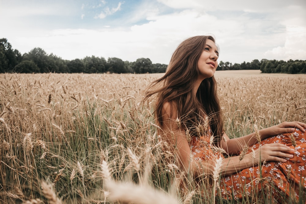 woman sitting on green grass field during daytime