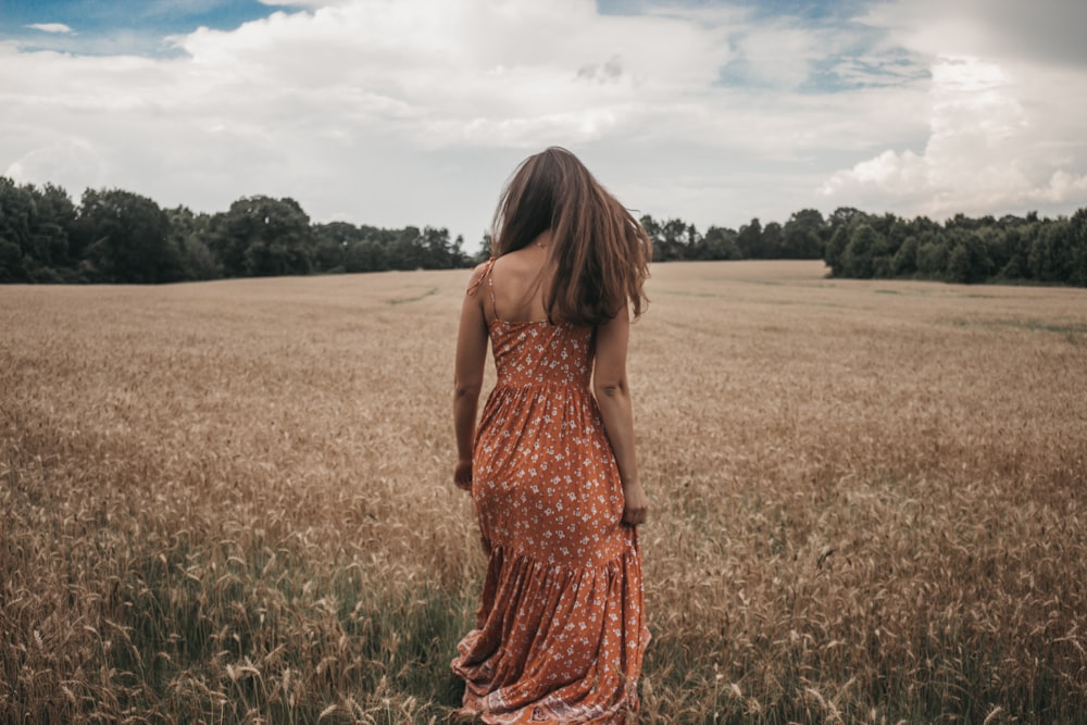 woman in orange dress on wheat field
