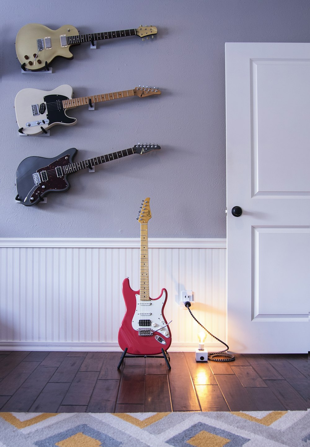 four assorted-color electric guitars