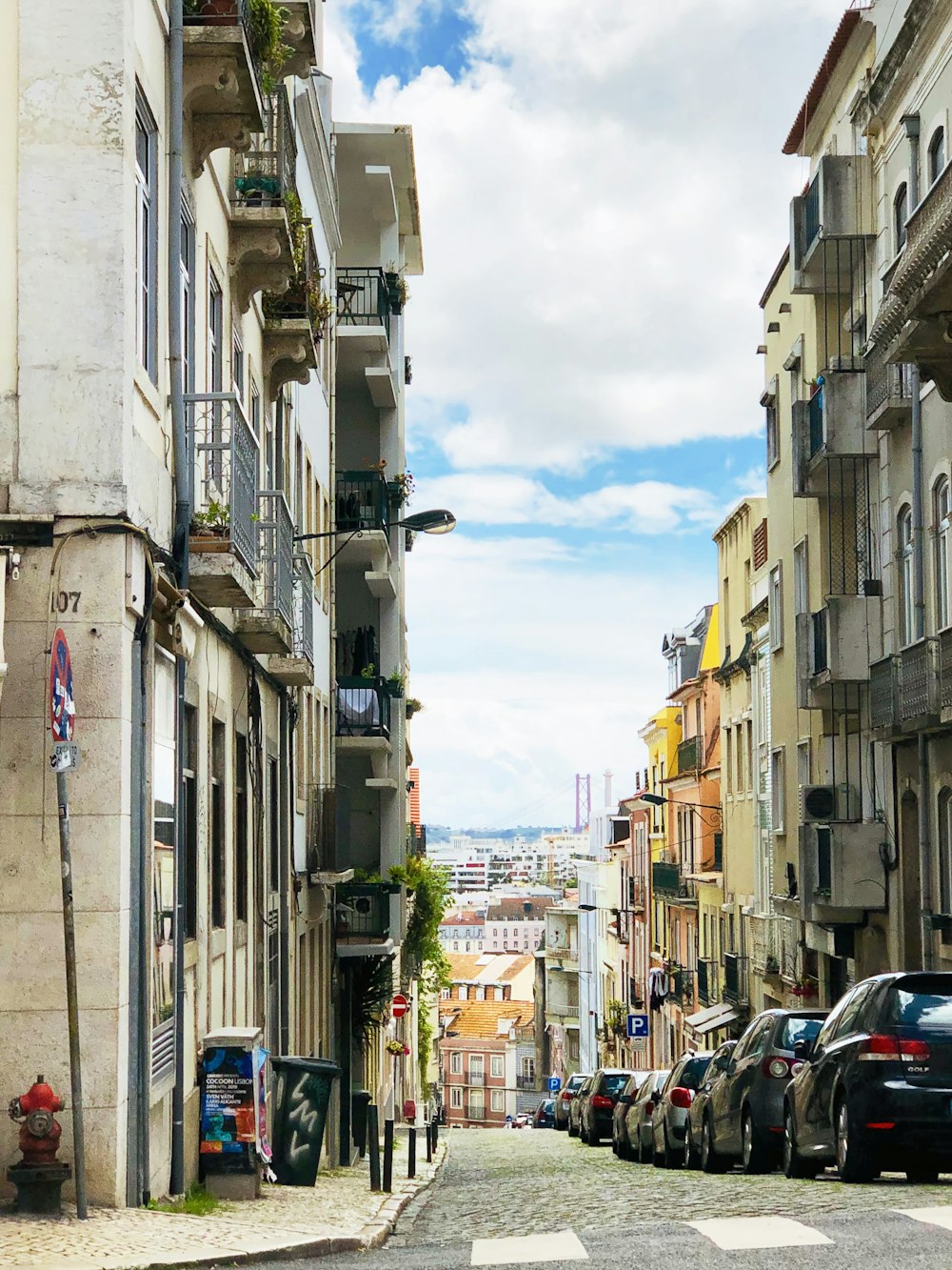 photography of vehicle parked on road between buildings during daytime