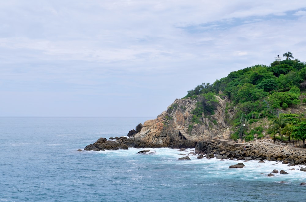 photography of green and brown mountain beside seashore during daytime