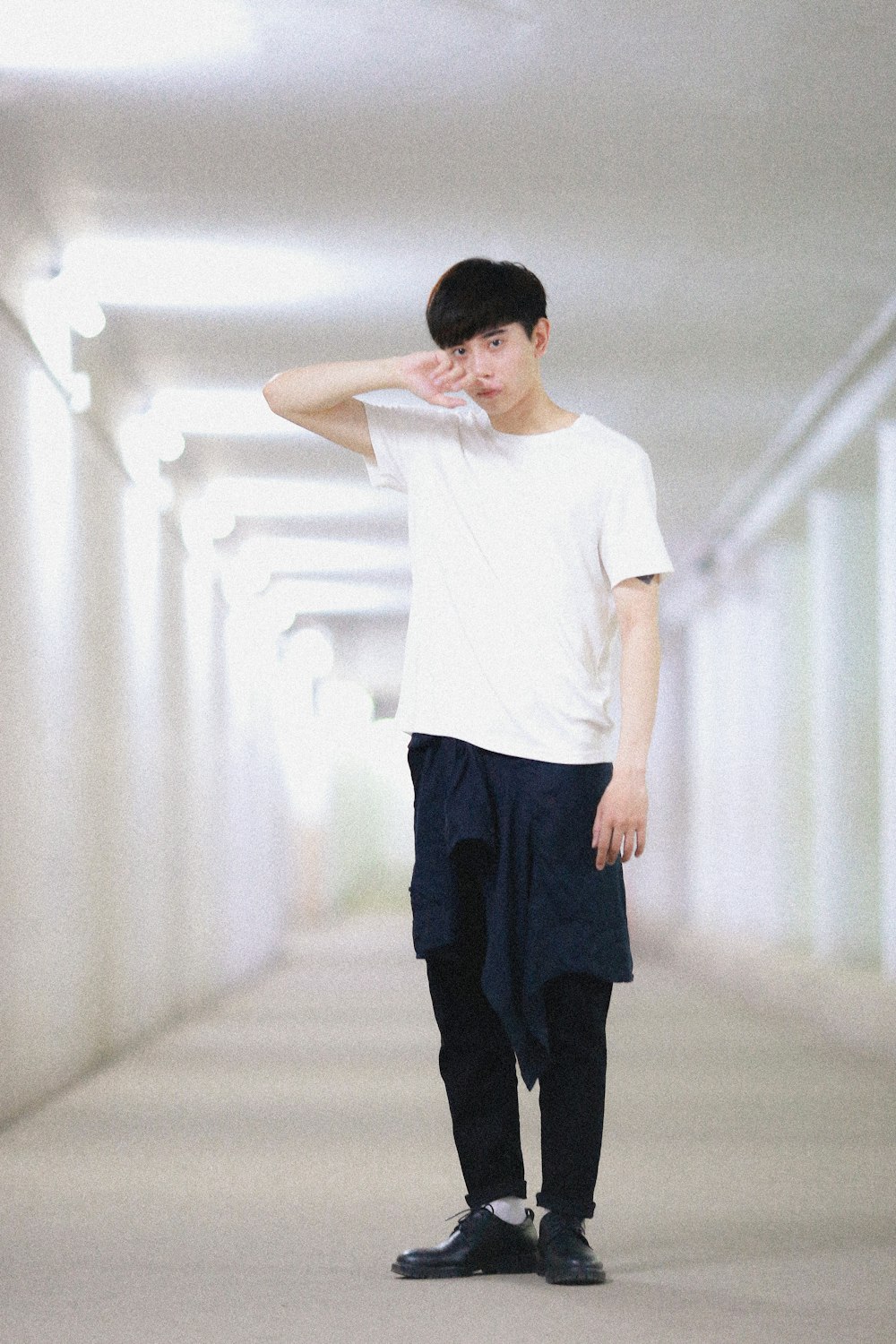 man wearing white crew neck shirt standing on hallway