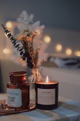 A cozy arrangement of scented candle sets glowing softly on a wooden table.