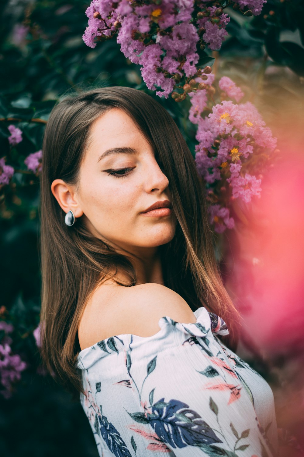 woman standing beside purple petaled flowers