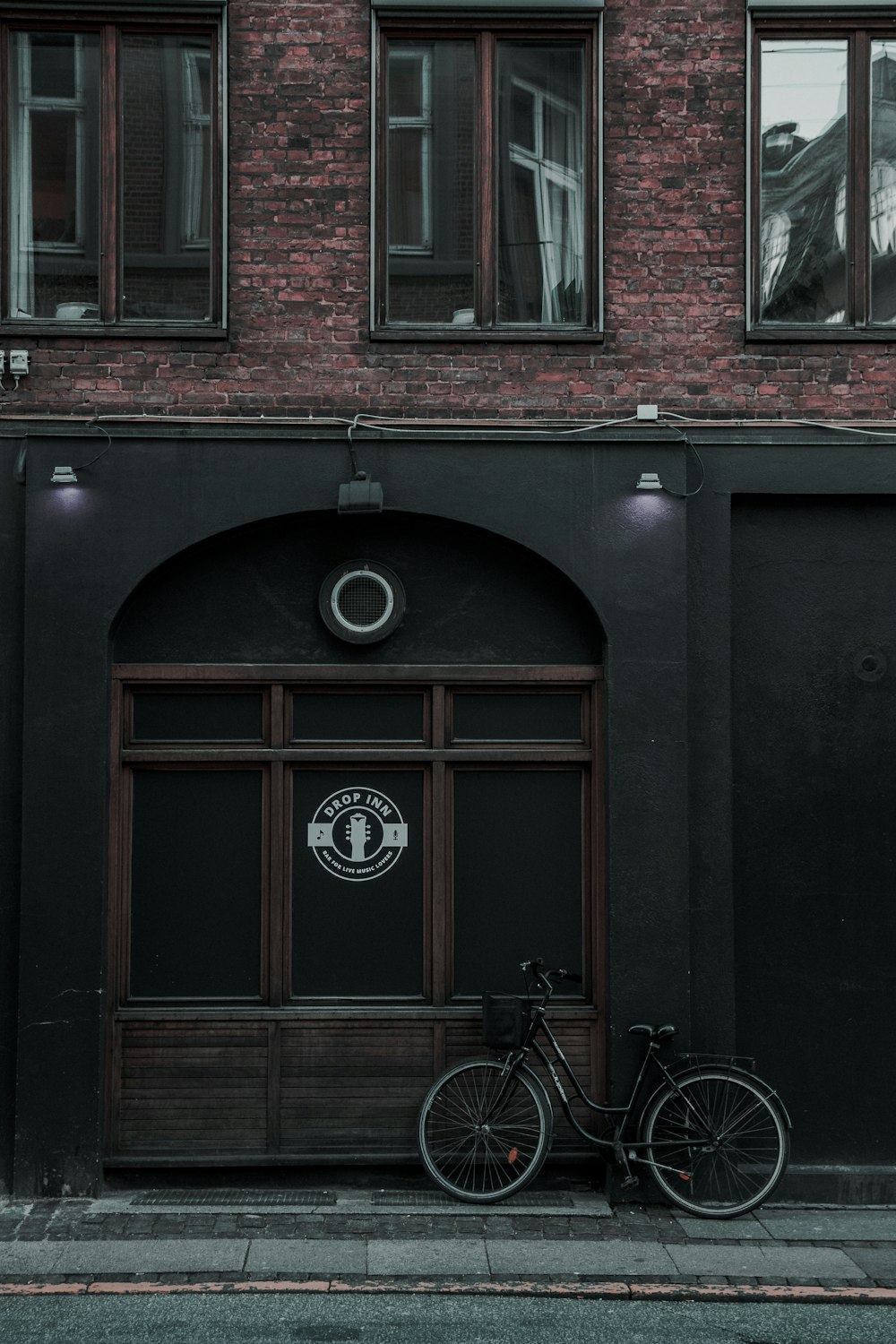 black city bike parked beside building during daytime