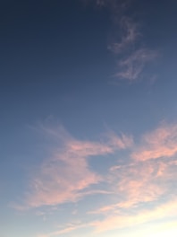 Soft pastel sky with gentle rays of sunlight breaking through fluffy clouds, evoking a sense of peace and hope.