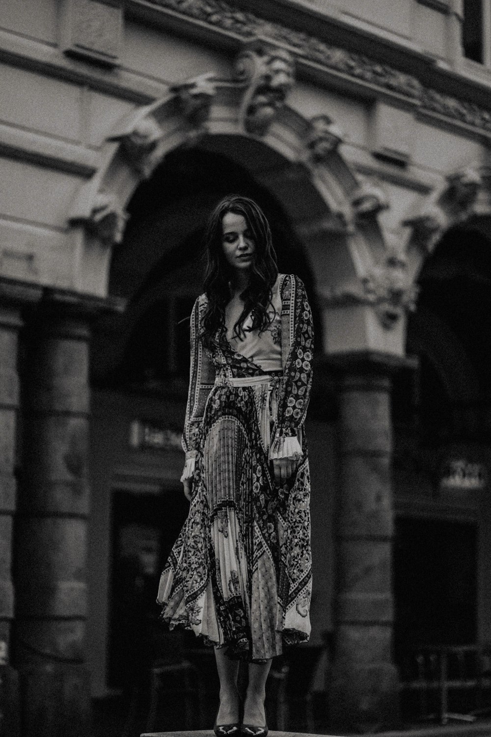 Mujer con maxi vestido blanco y negro cerca de un edificio blanco