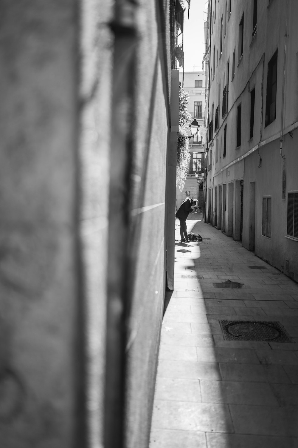 grayscale photography unknown person standing alleyway