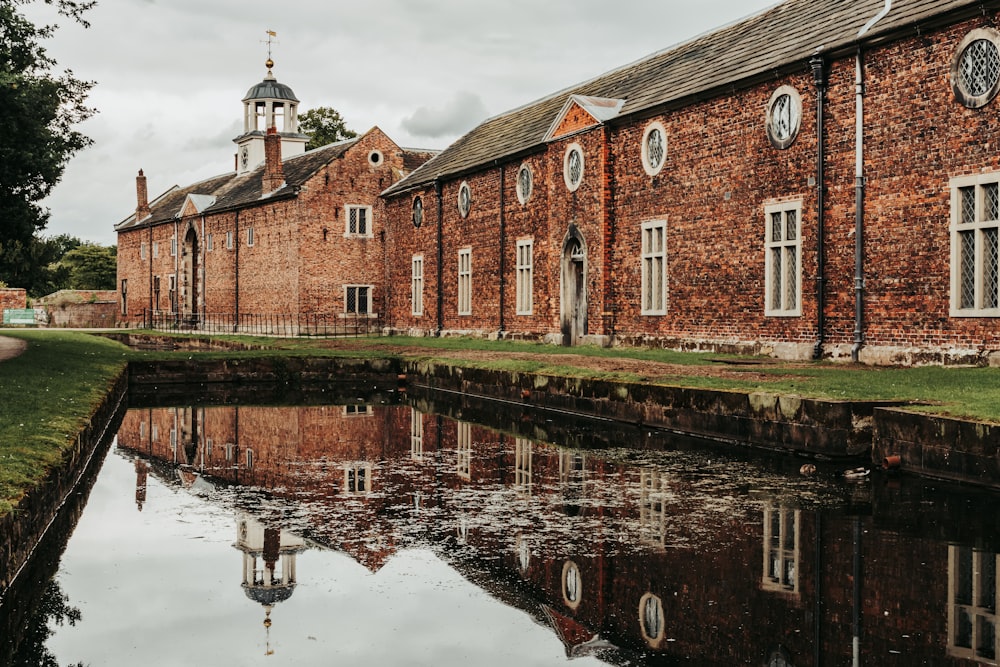 brown brick building near pond at daytime