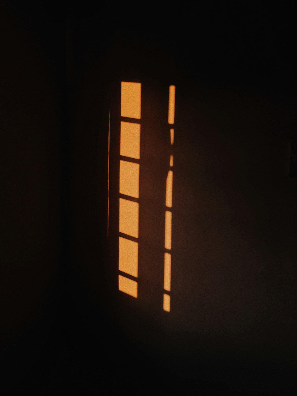 the shadow of two windows on a wall