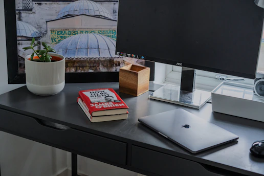 A vibrant, modern workspace with a laptop, coffee cup, and political books scattered around.