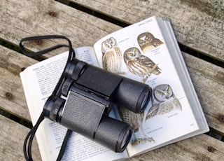 black binoculars on opened book