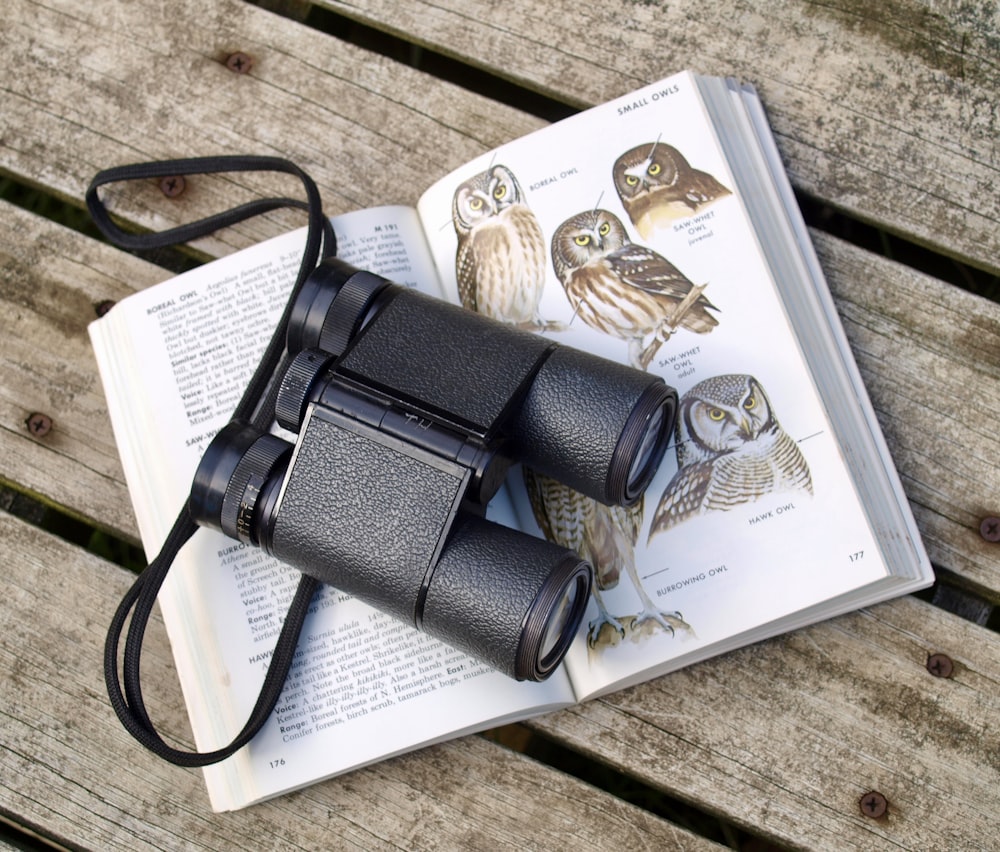 black binoculars on opened book
