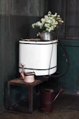 A calm, homey corner featuring a vintage washing machine surrounded by plants.