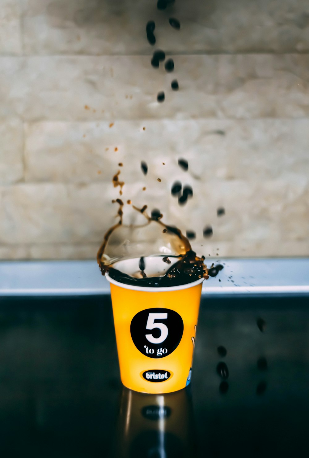 granos de café negro caídos en una taza de café
