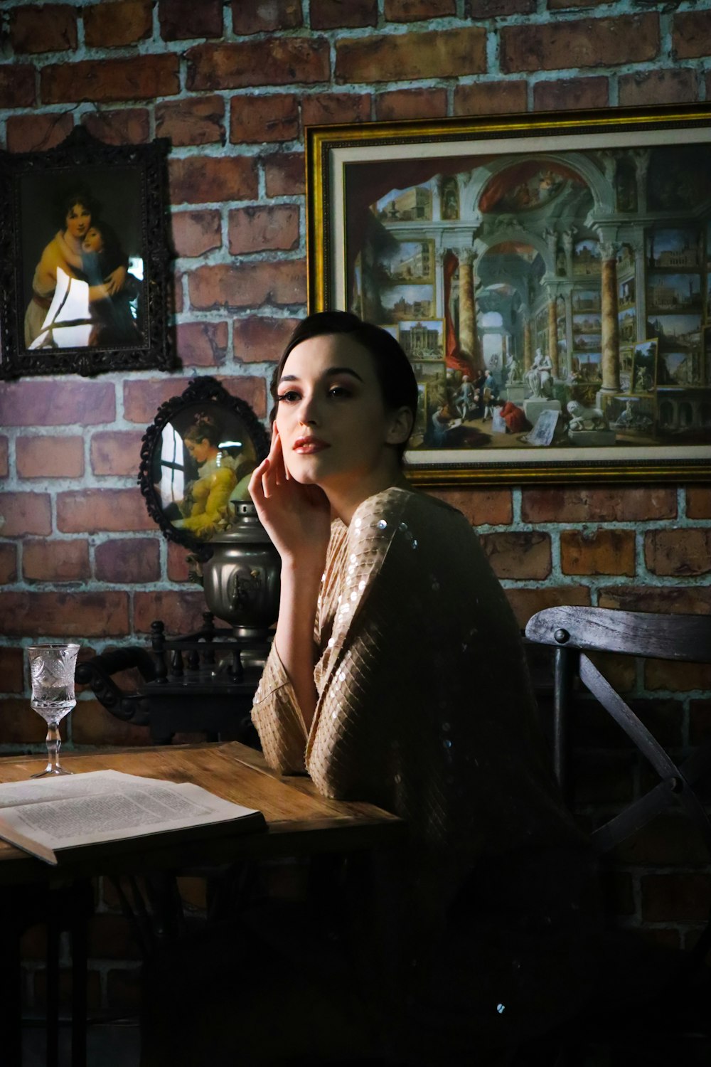 woman sitting beside table with opened book